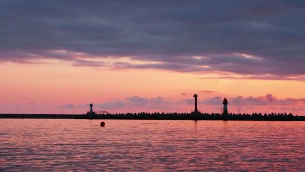 Siluet mercusuar dengan latar belakang matahari terbenam berwarna-warni. Pelabuhan Sochi, Rusia. — Stok Video