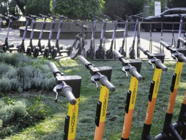 SOCHI, Rusya - 27 Mayıs 2021. Şehir parkında kiralık scooter 'lar. Turistler ve yerel halk için çevre dostu ve rahat şehir ulaşımı.