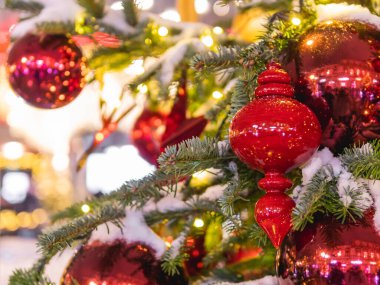 Parlak süslemeli Noel ağacı. Yılbaşı kutlaması için kırmızı toplar ve ampullerle süslenmiş fidan ağacı..