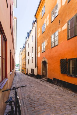 Stockholm 'ün tarihi bölgesinde parlak güneş dar sokaklara yansıyor. Gamla Stan 'de eski moda bir bina. İsveç.