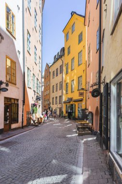 STOCKHOLM, İSVEÇ - 6 Temmuz 2017. Şehrin tarihi bölgesinde turistler dar sokaklarda yürürler. Gamla Stan 'deki eski moda binalar.