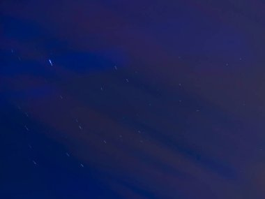 Mavi gökyüzündeki yıldız izleri. Yıldızlı gece gökyüzüne uzun süre maruz kaldım. Uzaydan gelen doğal ışık.