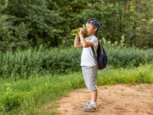 Ragazzo Assetato Tiene Mano Una Bottiglia Verde Riutilizzabile Con Acqua — Foto Stock