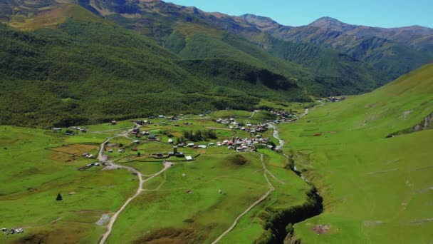 Aerial view of an alpine village in the middle of a sunny summer day. — Stok Video