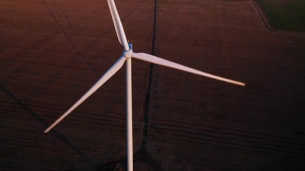 Luchtfoto van een windmolen met akkers op de achtergrond bij zonsondergang. — Stockvideo