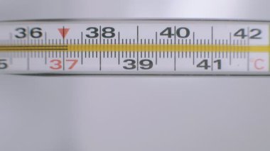 Açık arkaplanda hareket eden cıvalı cam termometre.