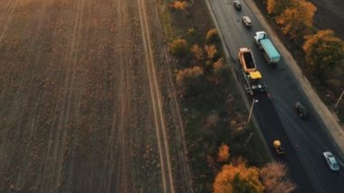 Gün batımında yol onarımının havadan görüntüsü. Yol yeniden açılıyor. Bir sonbahar akşamı gün batımında yol tamir alanında trafik tıkanmış..