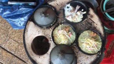 Vietnamlı bir kadın gevrek Vietnam krepleri pişiriyor.