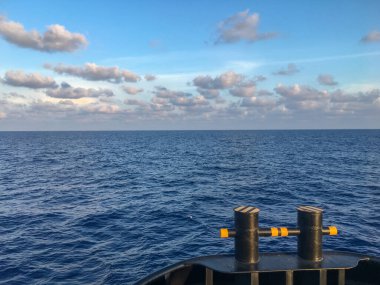 Vietnam 'daki büyük bir geminin pruvasından mavi denize ve bulutlu gökyüzüne bakıyorum.