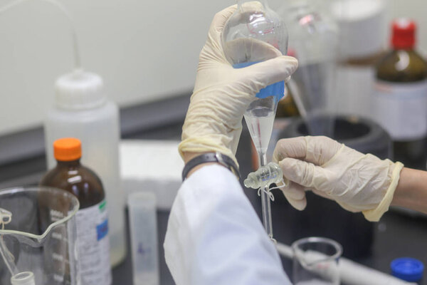 Closeup of hand of scientist making an experiment in the laboratory