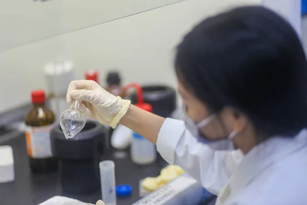 Крупный План Азиатской Женщины Ученого Проверяющей Стеклянную Фляжку Эксперимента Лаборатории — стоковое фото
