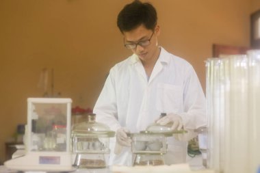 Vietnamlı bilim adamı laboratuvarda kurutucuyu kontrol ediyor.