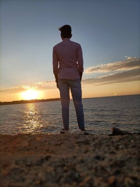 Kumsalda duran yakışıklı bir adam.