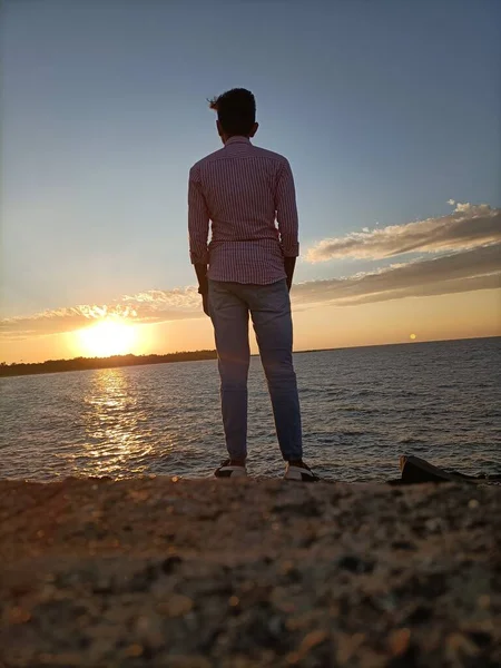 Kumsalda duran yakışıklı bir adam.