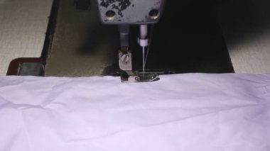Dikiş makinesinde çalışan bir terziye yakın çekim.