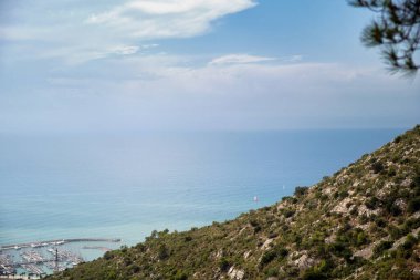 Castelldefes 'in kayalık dağlarının manzarası doğal parkı ve kumsalını sakin denizle kaplıyor ve sabahları gökyüzü bulutlarla kaplı..