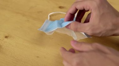 Adam yeni bir tıbbi maske alıyor ikiye bölünmüş ve farklı katmanlarını gösteriyor.