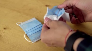 Adam yeni bir tıbbi maske alıyor ikiye bölünmüş ve farklı katmanlarını gösteriyor.