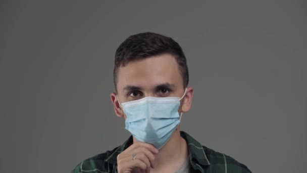 Fiatal kaukázusi férfi kilégzés gőz gőzből orvosi maszkon keresztül — Stock videók