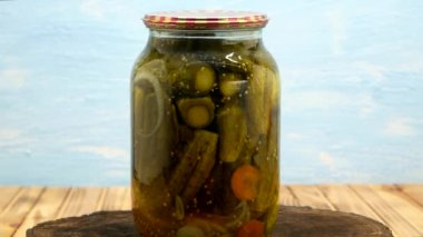 Preservations, conservation. Salted, pickled cucumbers in a jar on an wooden table. Pickling cucumbers at home. Vegetable harvest conservation. Close up.