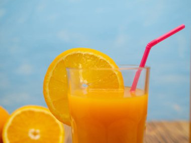 Fresh juice, mix fruits, orange drink on a blue background. Glass with orange cocktail.