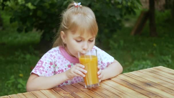 Little Girl Drinks Orange Juice Garden Child Drinks Orange Juice — Stockvideo