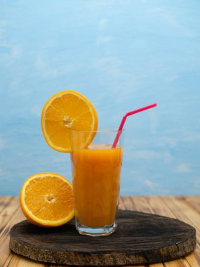 Orange juice in a glass with a slice of orange and an straw.