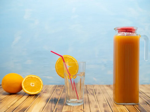 Jug Fresh Fruit Juice Empty Glass Wooden Table Blue Background — Stock Photo, Image