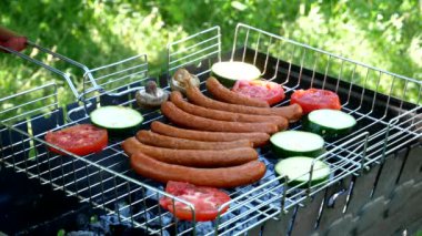 Roasting on the grill. The cook puts champignon mushrooms on the grill. Fried sausages and vegetable on the grill outdoors. B-B-Q. Fried food is fried and smoked on charcoal grills. Close-up