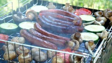 Roasting on the grill. Fried sausages and vegetable on the grill outdoors. B-B-Q. Fried food is fried and smoked on charcoal grills. Picnic and camping street food concept. Close-up