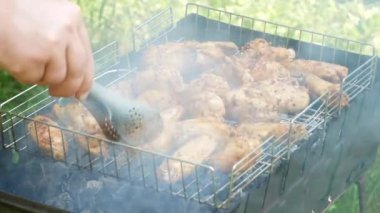Izgarada kızartılıyor. B-B-Q. Kızarmış yiyecekler kızartılmış ve kömür ızgaralarında tütsülenmiş. Lezzetli tavuk etleriyle ızgara yapılmış. Piknik ve kamp sokak yemekleri konsepti. Yakın plan. Yavaş çekim.