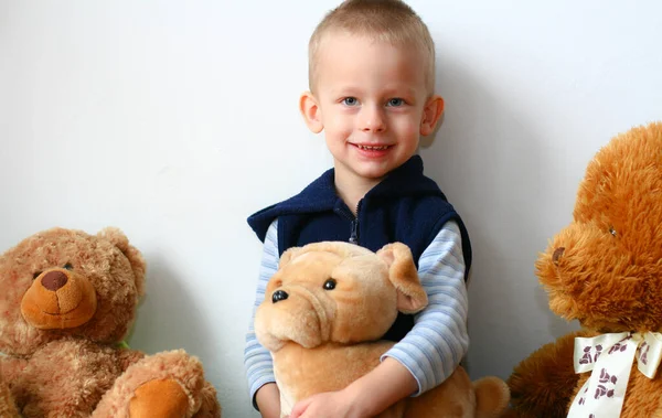 3岁的男孩摆姿势 泰迪熊抱着一只泰迪熊 看着摄像机 笑着面对着白墙 — 图库照片