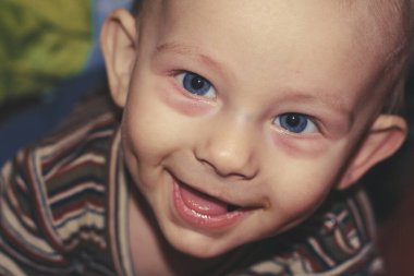 Bir yaşındaki erkek bebek doğrudan kameraya bakıyor.