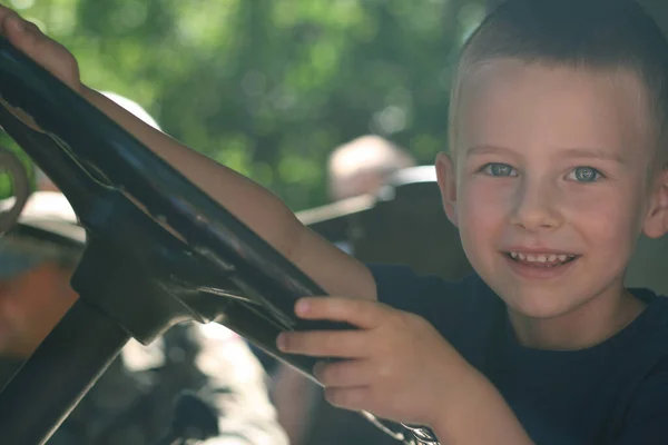 4岁的小男孩坐在方向盘后面假装开车 — 图库照片