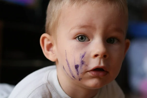 无忧无虑的两岁男孩 刚刚用墨水画了脸 看着相机 — 图库照片