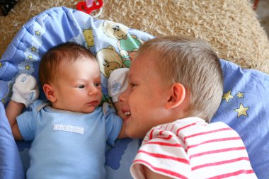 İki haftalık yeni doğmuş erkek çocuk, sıkı tutunma eldivenleriyle dört yaşındaki ağabeyi ile buluşuyor.