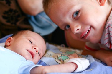 İki haftalık yeni doğmuş erkek çocuk, sıkı tutunma eldivenleriyle dört yaşındaki ağabeyi ile buluşuyor.