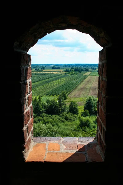 View on fields and meadows through window of medieval castle tower in Mazovia, Poland