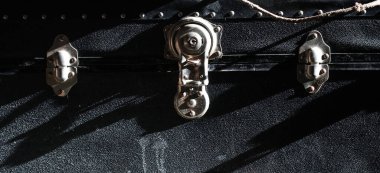 Close up on metal closure of very old black trunk