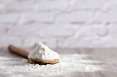 Tahta zemin üzerinde bir kaşık beyaz un. Boşluğu kopyala.