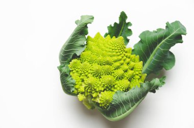 Romanesco broccoli with leaves on white background with copy space. 
