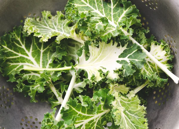 White and green kale leaves in a colander. 