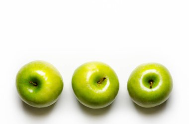 Three green apples on white background with copy space.
