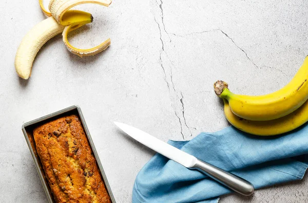 Ein Bananenbrot Mit Schokoladenstücken Ein Paar Bananen Und Einer Blauen — Stockfoto