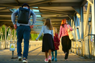 HAMBURG, Almanya - 21 Eylül 2019: Çocuklar aileleriyle birlikte okula gidiyorlar. Anne ve babasıyla yürüyen iki kız. Anne, baba ve okul çocukları briç geçmişinde 