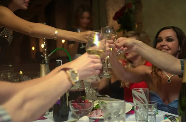 パーティーテーブルでメガネをかけている若者のチームです 誕生日パーティーを祝う若い多民族の人々のグループ屋内と白ワインとクリンクグラス — ストック写真