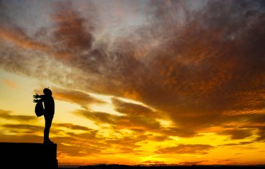 Sırt çantalı sırt çantalı sırt çantalı silueti vadinin yukarısındaki kayalık manzarada duruyor.. 