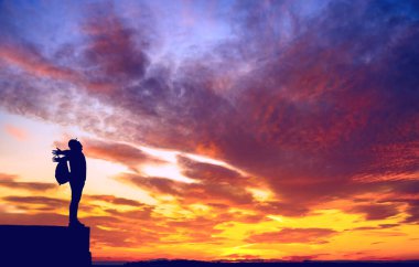 Sırt çantalı sırt çantalı sırt çantalı silueti vadinin yukarısındaki kayalık manzarada duruyor.. 