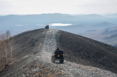 Dağ yolunda dört tekerli motosiklet kullanan yarışçıların hava manzarası. Vahşi bir yolda dört tekerli bisiklet. ATV. Arkadan bak. Rusya, Karabaş, Chelyabinsk bölgesi