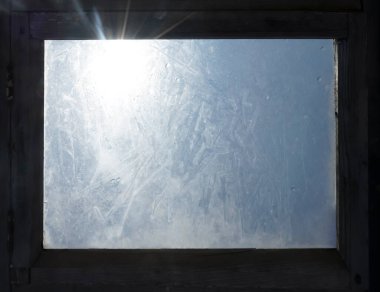 Kaliteli odada parlak güneş ışınları kirli camlı eski ahşap pencere çerçevesinden parlıyor.